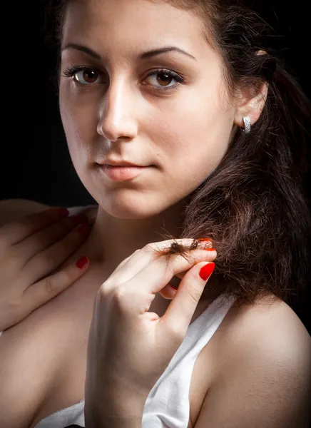 Retrato de menina em singlet branco segurando fio de cabelo escuro — Fotografia de Stock