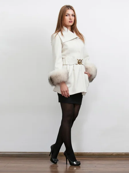 Junge Frau trägt weißen Mantel mit Pelzärmeln — Stockfoto