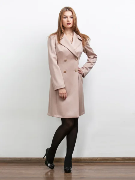 Mulher vestindo casaco clássico bege no estúdio — Fotografia de Stock