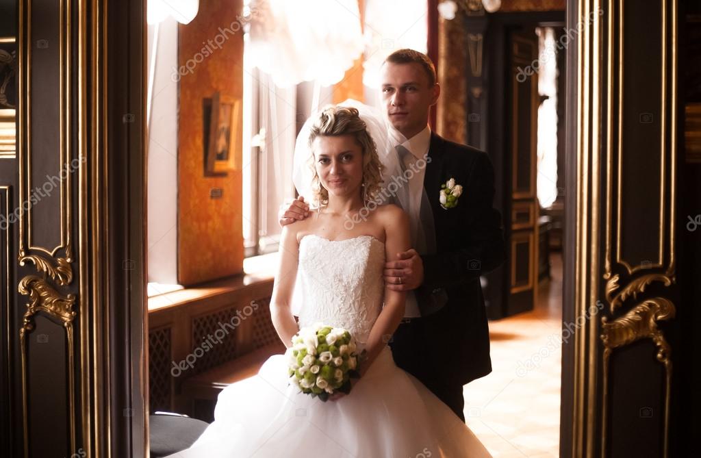 Newly married couple standing in doorway at old palace