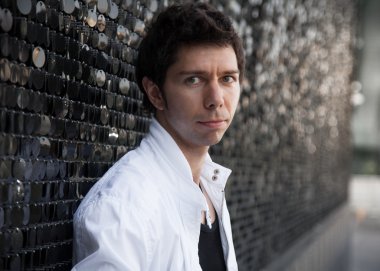 esmer adam beyaz ceketli siyah duvara yaslanmış