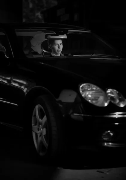 Ritratto di bell'uomo che guida auto di lusso di notte — Foto Stock
