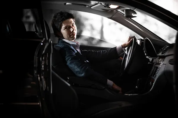 Portrét skrz otevřené dveře řidiče drží volant — Stock fotografie