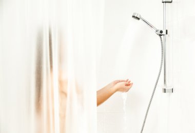 duş, perdenin arkasında duran ve su altında elele kadın