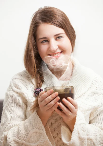 Mujer morena sosteniendo una taza de té. Vapor formando corazón — Foto de Stock