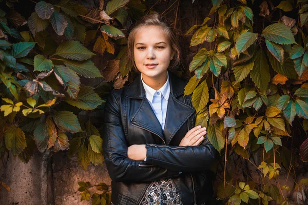 Stylish woman holding hands crossed against ivy background — Stock Photo, Image