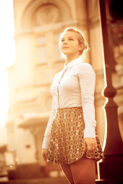 Portrait of young girl posing against building at sunset — Stock Photo, Image