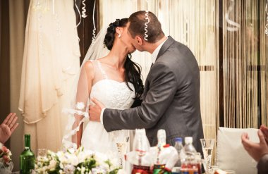 Gelin ve damat Ziyafet masada arkasında tutkuyla öpüşme
