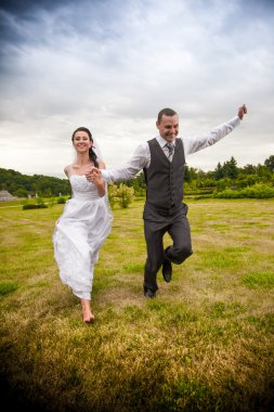 evli çift koşu ve ellerini tutarak Park'ta atlama