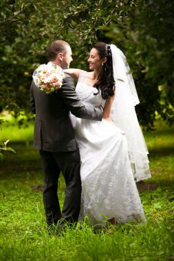 Çift düğün sarılma ve birbirine Garden'da bakarak