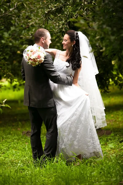 Couple de mariage étreignant et se regardant au jardin — Photo