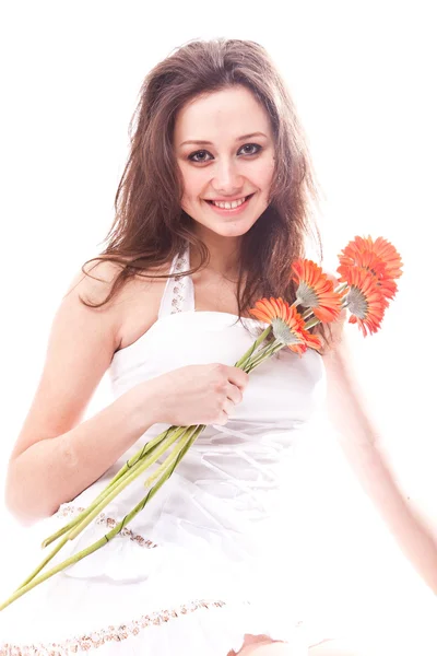 Portrait of cute young woman sitting on floor with red flowers — Stock Photo, Image