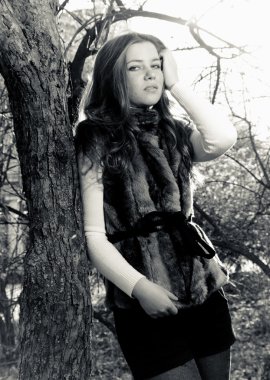 kürk ceket ağacına yaslanmış kadının bırakır