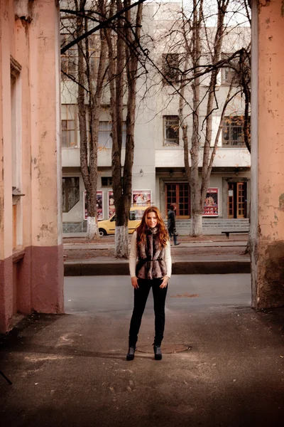 Mujer delgada de pie en la calle entre dos edificios altos — Foto de Stock