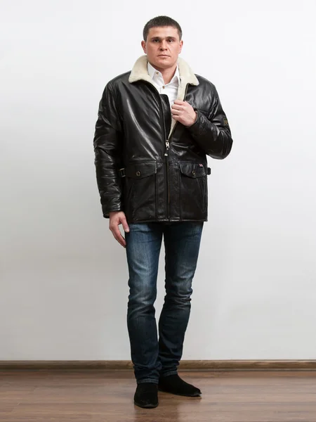 Adult man unzipping leather coat with fur collar — Stock Photo, Image