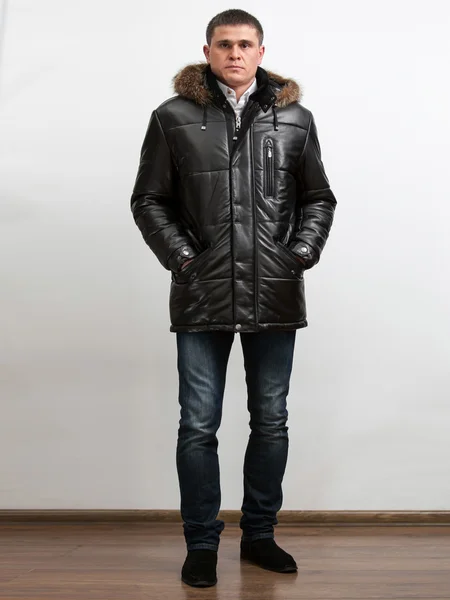 Großer Mann trägt schwarzen Wintermantel und hält die Hände in den Taschen — Stockfoto