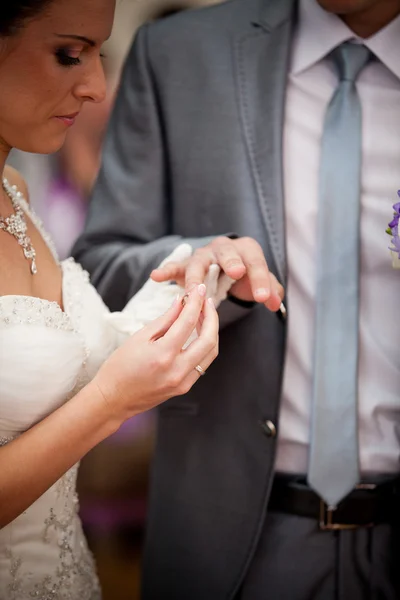 Giovane sposa mettendo fede nuziale sulla mano sposi — Foto Stock