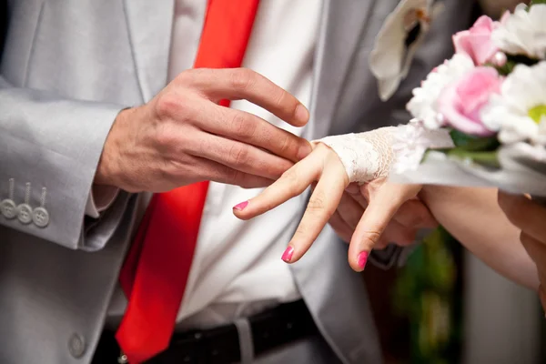 Foto de novio poniendo anillo de bodas en el dedo de las novias —  Fotos de Stock
