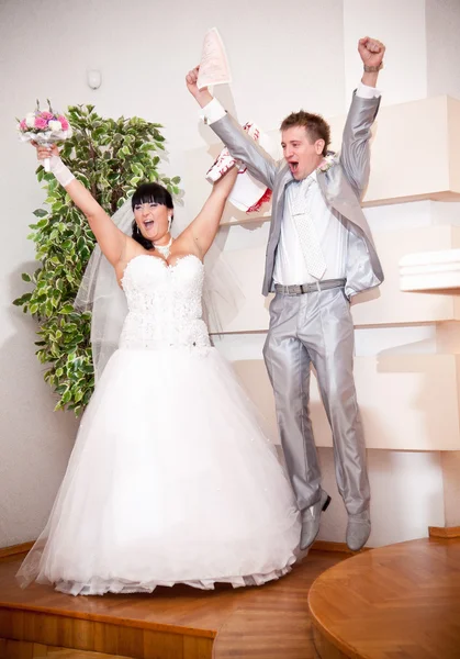 Newly married couple jumping up high at wedding office — Stock Photo, Image
