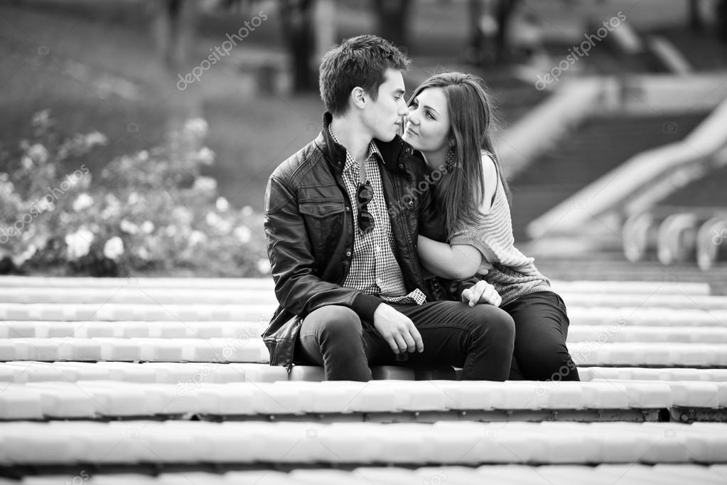 Photo of young couple in love kissing on bench