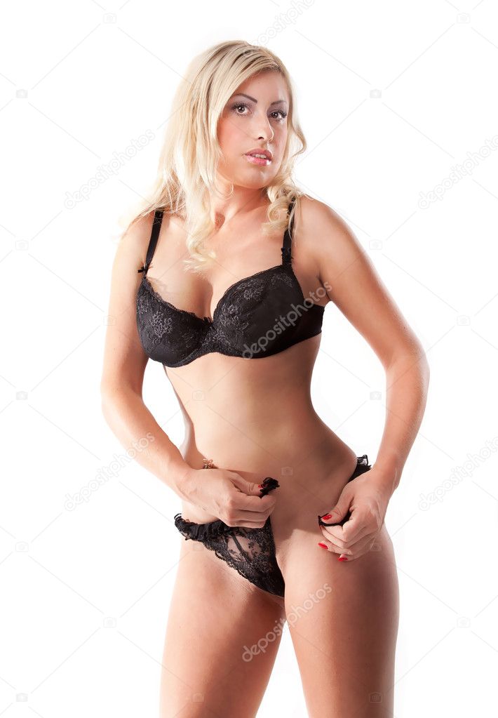 Slim woman taking off black panties against white background