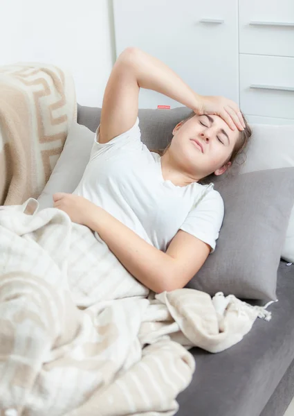 Woman taking her temperature in bed and having headache — Stock Photo, Image