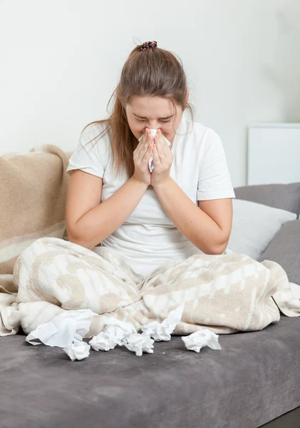 Brunette woman in blanket blowing nose — Stock Photo, Image