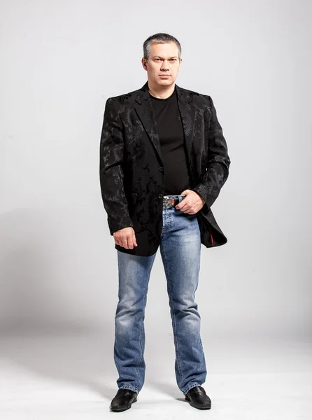 Studio portrait of adult man in jeans and black jacket — Stock Photo, Image