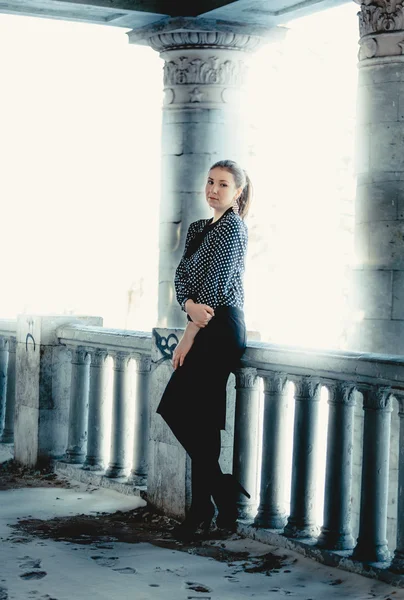 Full length portrait of elegant woman leaning against columns — Stock Photo, Image