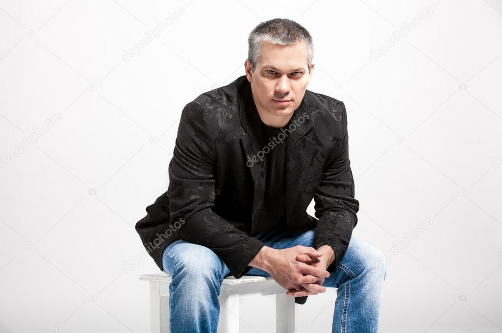 Handsome man with gray hair sitting on chair
