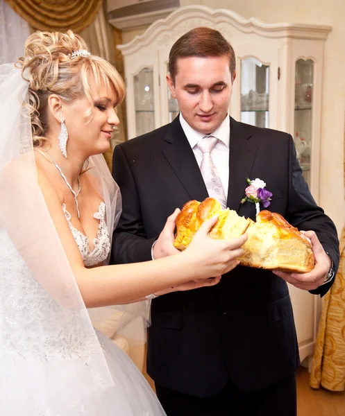 Bride and groom breaking traditional loaf — Stock Photo, Image