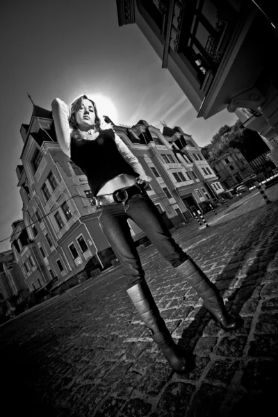 Sexy woman with long legs standing against old buildings — Stock Photo, Image