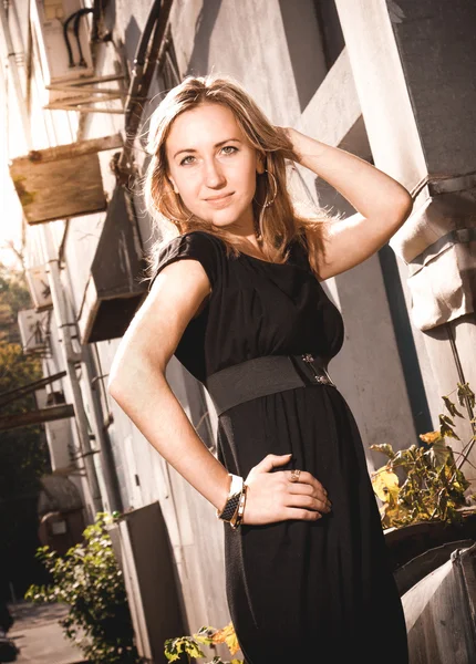 Retrato de mujer hermosa en vestido negro contra edificio viejo — Foto de Stock