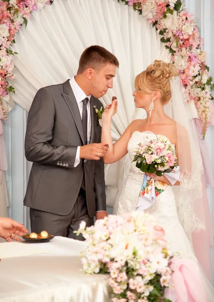 Young bride giving chocolate candy to groom — Stock Photo, Image