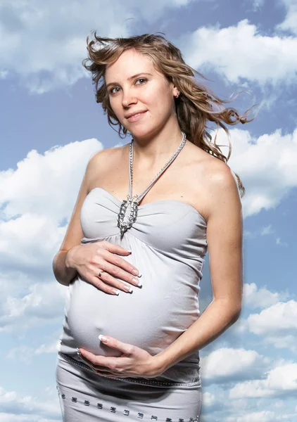 Portret van mooie zwangere vrouw tegen blauwe hemel — Stockfoto