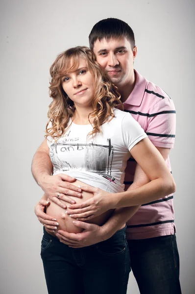 英俊的男人从后面拥抱怀孕的妻子 — 图库照片