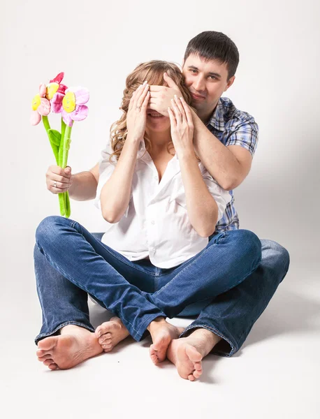 Homem fechando os olhos da esposa grávida e dando-lhe flor — Fotografia de Stock