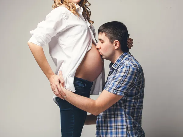 Jeune homme embrassant le ventre de la femme enceinte — Photo