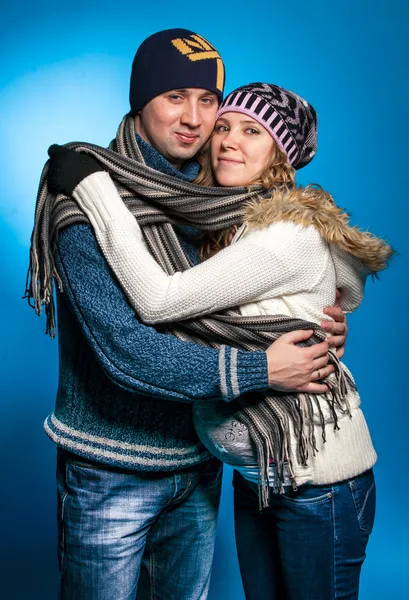 Portrait of couple in warm clothes hugging and looking at camera — Stock Photo, Image