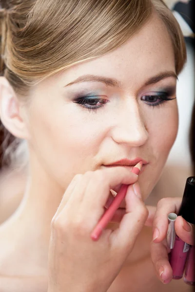 Portrait of stylist painting brides lips with lipstick — Stock Photo, Image