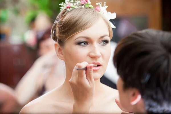 Retrato de estilista fazendo maquiagem para noiva loira — Fotografia de Stock