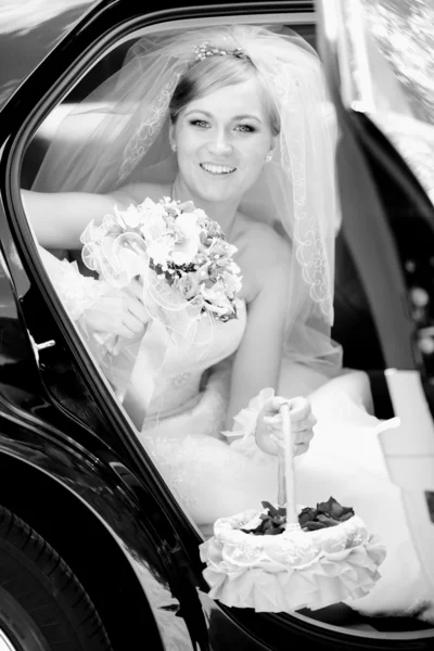 Portrait of beautiful bride sitting on backseat of car — Stock Photo, Image