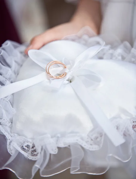 Testigo sosteniendo cojín blanco con anillos de boda —  Fotos de Stock