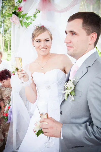 Coppia appena sposata che tiene bicchieri di champagne — Foto Stock