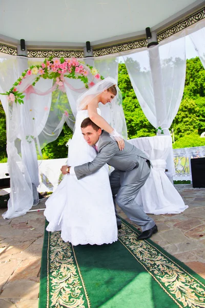 Novio poniendo novia en hombro y tratando de robar su — Foto de Stock