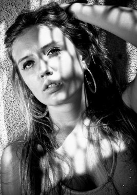 seksi kadın yüzüne düşen gölge ile duvara yaslanmış