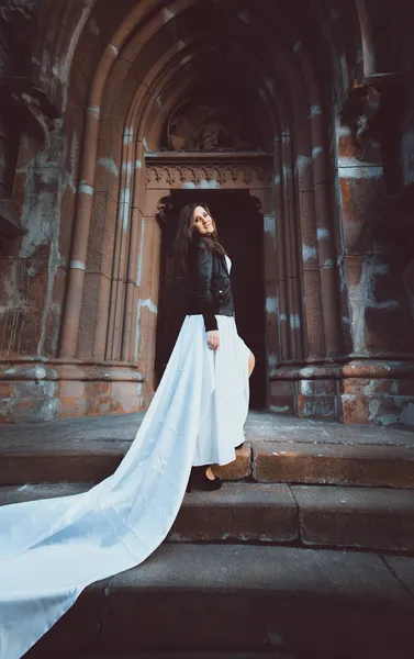 Frau im Kleid mit langem weißen Schleier schreitet auf alter Steintreppe — Stockfoto