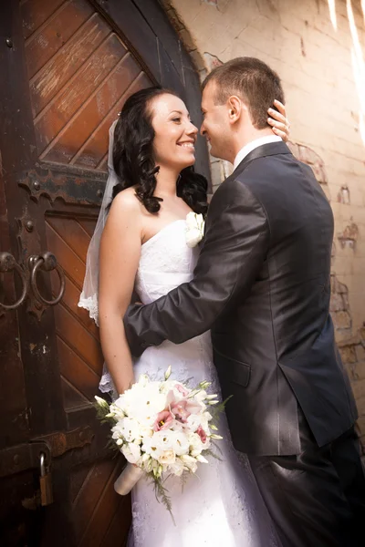 Beautiful brunette bride smiling at groom at yard of castle — Stock Photo, Image