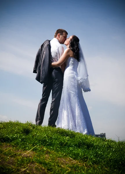 Żonaty para stoi na szczycie wzgórza przeciw błękitne niebo — Zdjęcie stockowe