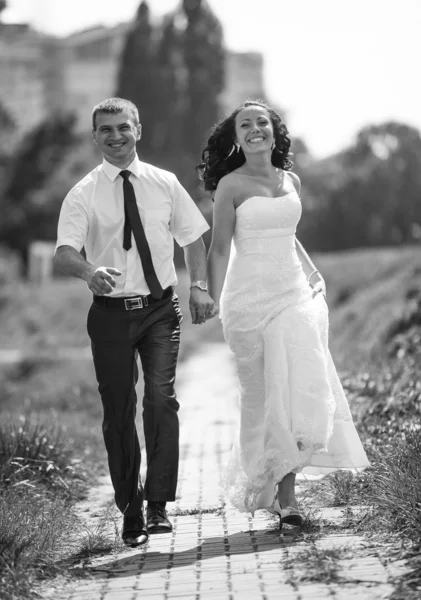 Photo de mariée et marié courant vite et souriant au parc — Photo